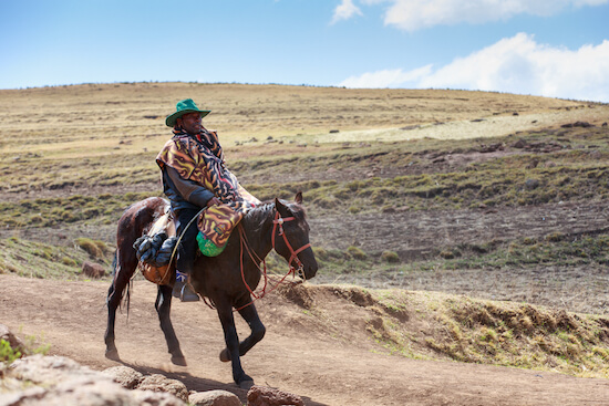 Basotho man dressed in typical Basotho blanket on horse - image by GilK/shutterstock.com