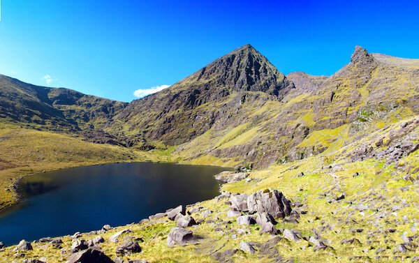 Carrauntoohill is Ireland's highest mountain, shown here with mountain lake and blue sky