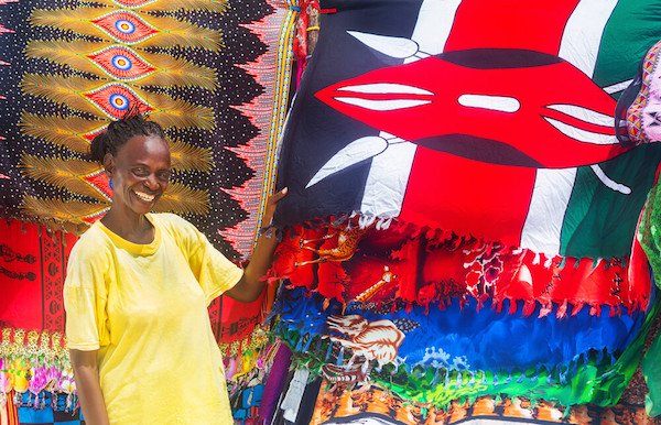 Smiling Kenyan woman with flag: MarKord / Shutterstock.com